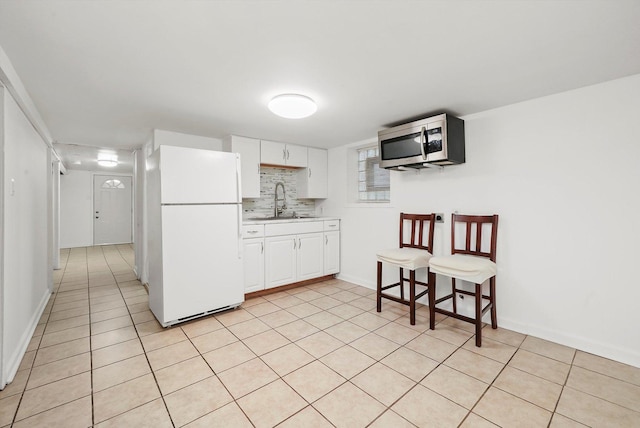 5331 W Schubert Ave, Chicago, IL 60639 - kitchen featuring freestanding refrigerator, stainless steel microwave, white cabinetry, and light tile patterned floors