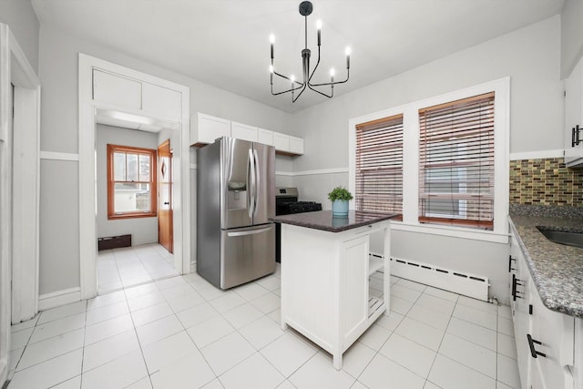 5331 W Schubert Ave, Chicago, IL 60639 - kitchen with appliances with stainless steel finishes, a baseboard radiator, a kitchen island, a chandelier, and white cabinets