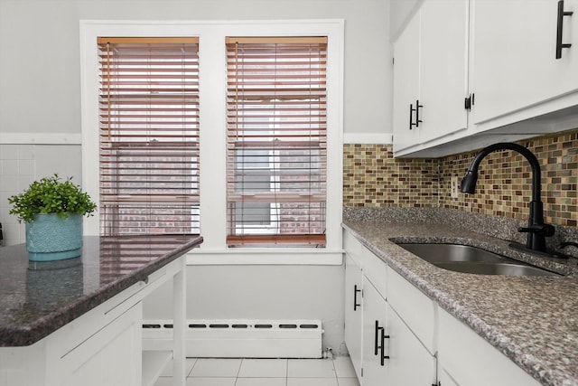 5331 W Schubert Ave, Chicago, IL 60639 - kitchen with white cabinetry, tile patterned flooring, backsplash, and a baseboard radiator