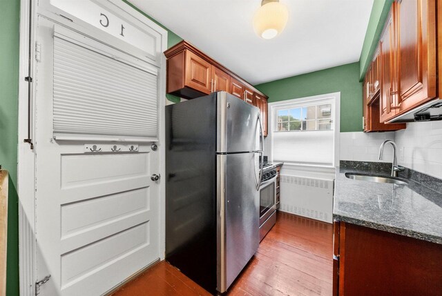 213 N Marion St Unit 1C, Oak Park, IL 60302 - kitchen featuring radiator, a sink, appliances with stainless steel finishes, dark stone countertops, and dark wood-style flooring