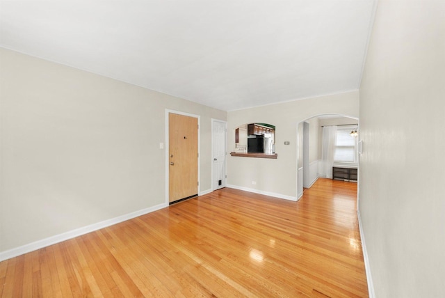 213 N Marion St Unit 1C, Oak Park, IL 60302 - unfurnished living room featuring arched walkways, baseboards, and light wood-style flooring