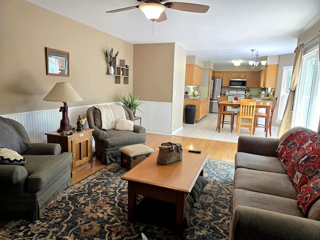 997 W Briarcliff Rd, Bolingbrook, IL 60440 - living area featuring ceiling fan, a chandelier, a wainscoted wall, and light wood finished floors