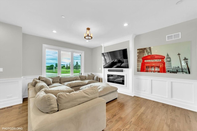 7218 S 78th Ave, Bridgeview, IL 60455 - living area with wainscoting, a decorative wall, wood finished floors, a glass covered fireplace, and recessed lighting