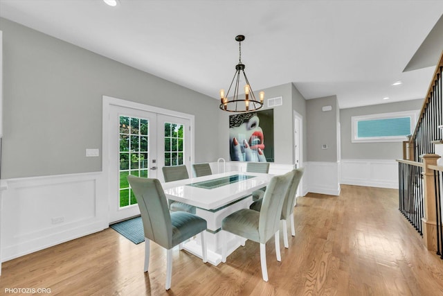 7218 S 78th Ave, Bridgeview, IL 60455 - dining area featuring a chandelier, a wainscoted wall, french doors, light wood-style floors, and a decorative wall