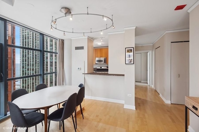201 N Westshore Dr Unit 2608, Chicago, IL 60601 - dining area featuring light wood-type flooring, baseboards, rail lighting, and crown molding
