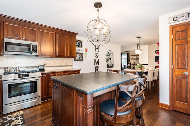 1714 Larson Ave, Saint Charles, IL 60174 - kitchen with appliances with stainless steel finishes, dark countertops, dark wood finished floors, decorative backsplash, and a center island