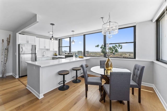 2700 N Hampden Ct Unit 24A, Chicago, IL 60614 - dining space featuring light wood-style flooring, baseboards, and a chandelier