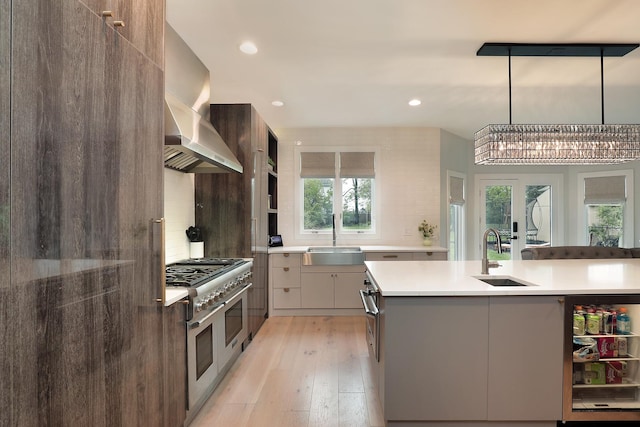 244 Kenmore Ave, Deerfield, IL 60015 - kitchen with wall chimney range hood, range with two ovens, a sink, light countertops, and recessed lighting