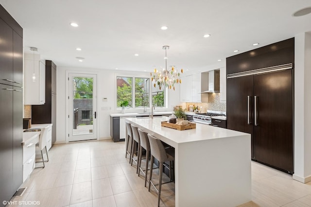 3635 N Paulina St, Chicago, IL 60613 - kitchen featuring high end appliances, modern cabinets, wall chimney range hood, decorative backsplash, and light countertops