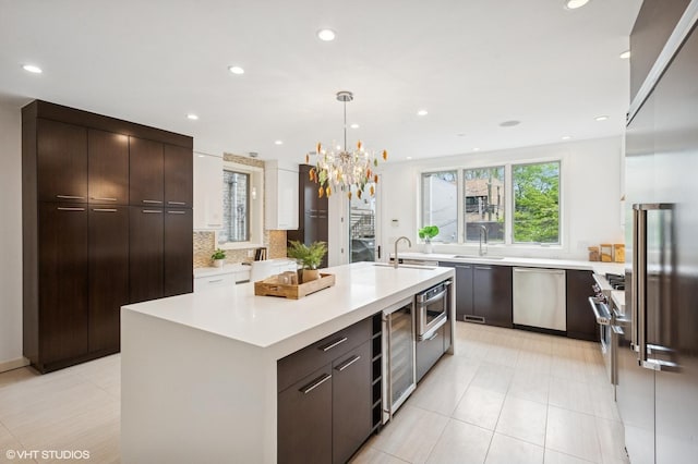3635 N Paulina St, Chicago, IL 60613 - kitchen featuring built in appliances, wine cooler, light countertops, a sink, and modern cabinets