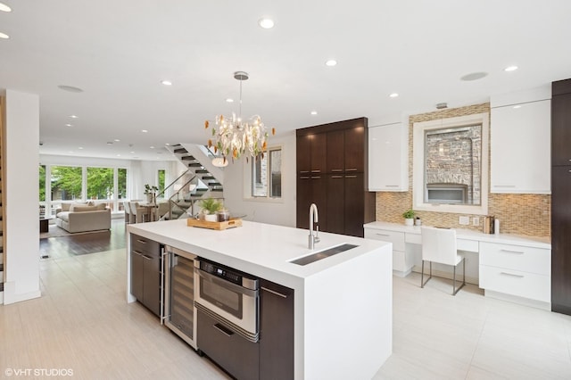 3635 N Paulina St, Chicago, IL 60613 - kitchen featuring modern cabinets, a sink, beverage cooler, white cabinetry, and tasteful backsplash