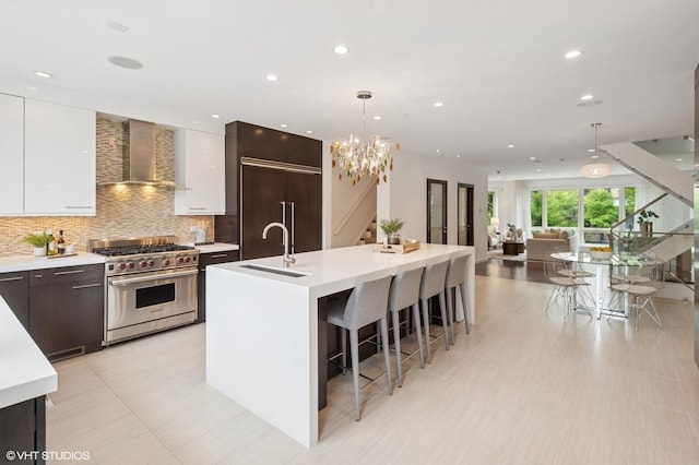 3635 N Paulina St, Chicago, IL 60613 - kitchen featuring high quality appliances, wall chimney range hood, a sink, modern cabinets, and a large island with sink