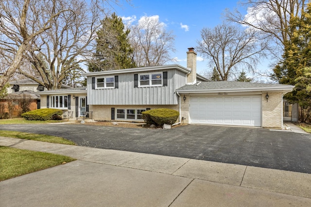 410 W Kirchhoff Rd, Arlington Heights, IL 60005 - tri-level home featuring a chimney, brick siding, and asphalt driveway