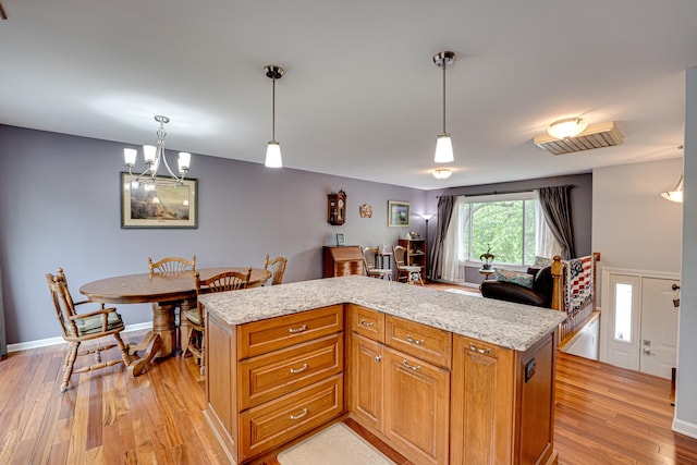 24W474 Surf Ct, Naperville, IL 60540 - kitchen with light wood-style flooring, light stone counters, decorative light fixtures, a chandelier, and a kitchen island
