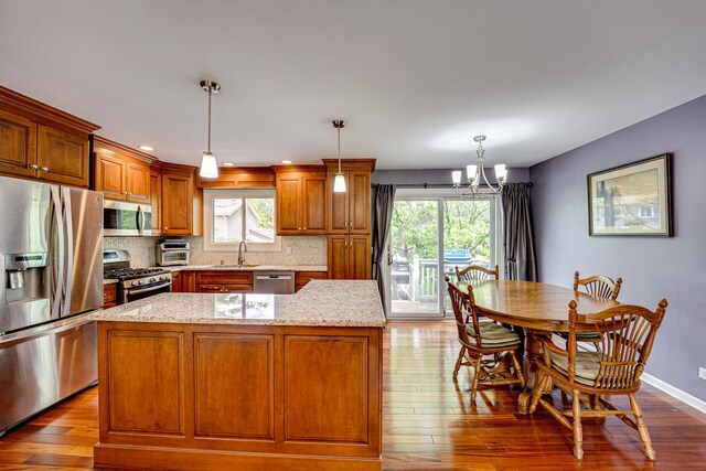 24W474 Surf Ct, Naperville, IL 60540 - kitchen featuring appliances with stainless steel finishes, a sink, a chandelier, dark wood-type flooring, and tasteful backsplash