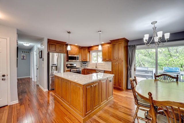 24W474 Surf Ct, Naperville, IL 60540 - kitchen with appliances with stainless steel finishes, brown cabinets, a chandelier, a center island, and a sink