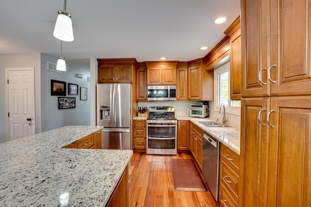 24W474 Surf Ct, Naperville, IL 60540 - kitchen featuring stainless steel appliances, a sink, brown cabinets, light wood-type flooring, and recessed lighting