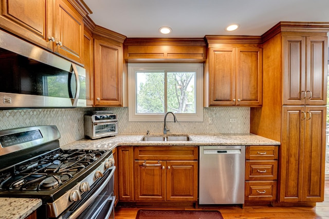 24W474 Surf Ct, Naperville, IL 60540 - kitchen featuring stainless steel appliances, a sink, wood finished floors, brown cabinetry, and recessed lighting