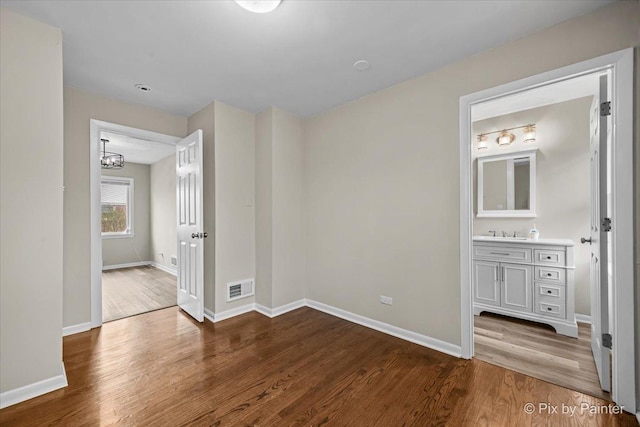 18371 Gladville Ave, Homewood, IL 60430 - unfurnished bedroom with wood finished floors, baseboards, and a chandelier