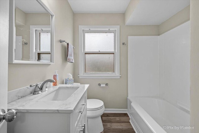 18371 Gladville Ave, Homewood, IL 60430 - bathroom featuring vanity, toilet, wood finished floors, baseboards, and washtub / shower combination