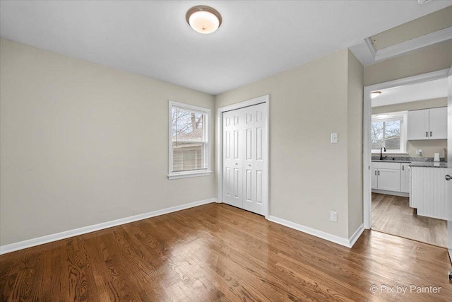 18371 Gladville Ave, Homewood, IL 60430 - unfurnished bedroom featuring a sink, multiple windows, wood finished floors, and baseboards