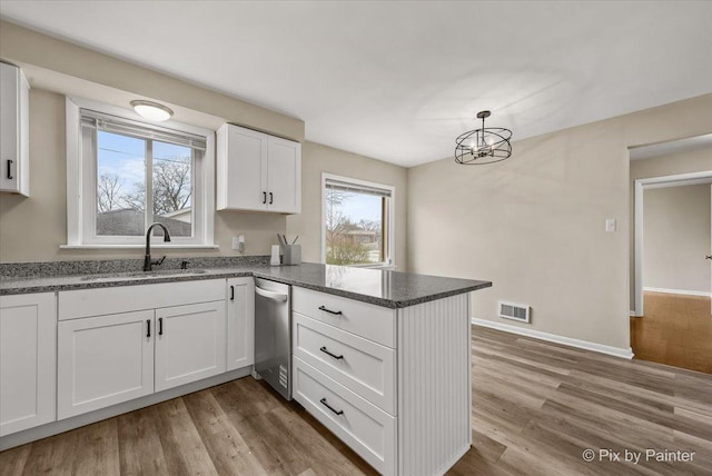 18371 Gladville Ave, Homewood, IL 60430 - kitchen with stainless steel dishwasher, a peninsula, a sink, white cabinetry, and dark stone counters