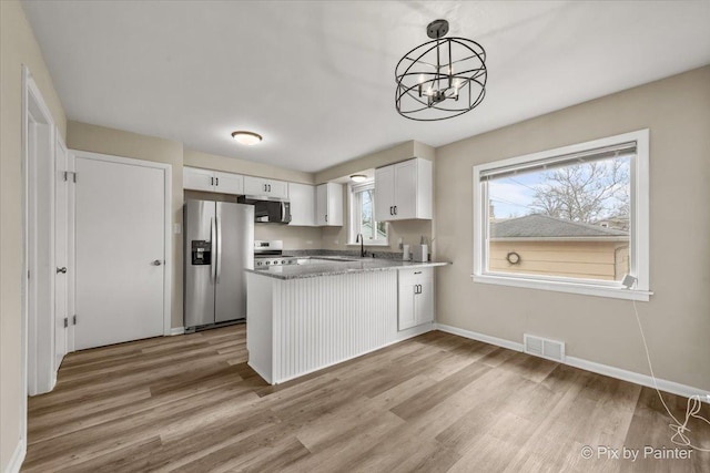 18371 Gladville Ave, Homewood, IL 60430 - kitchen with stainless steel appliances, light wood-style flooring, white cabinetry, a peninsula, and a chandelier