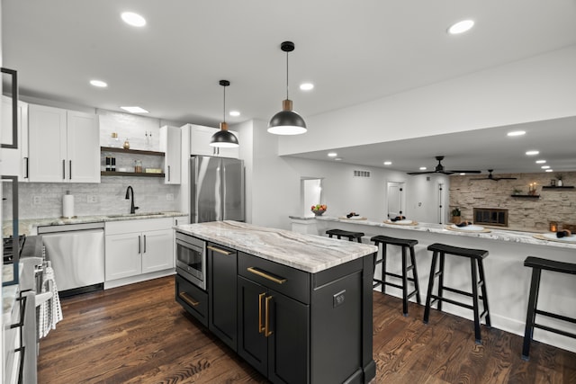 22308 S Eastcliff Dr, Joliet, IL 60404 - kitchen with appliances with stainless steel finishes, backsplash, a center island, white cabinetry, and recessed lighting