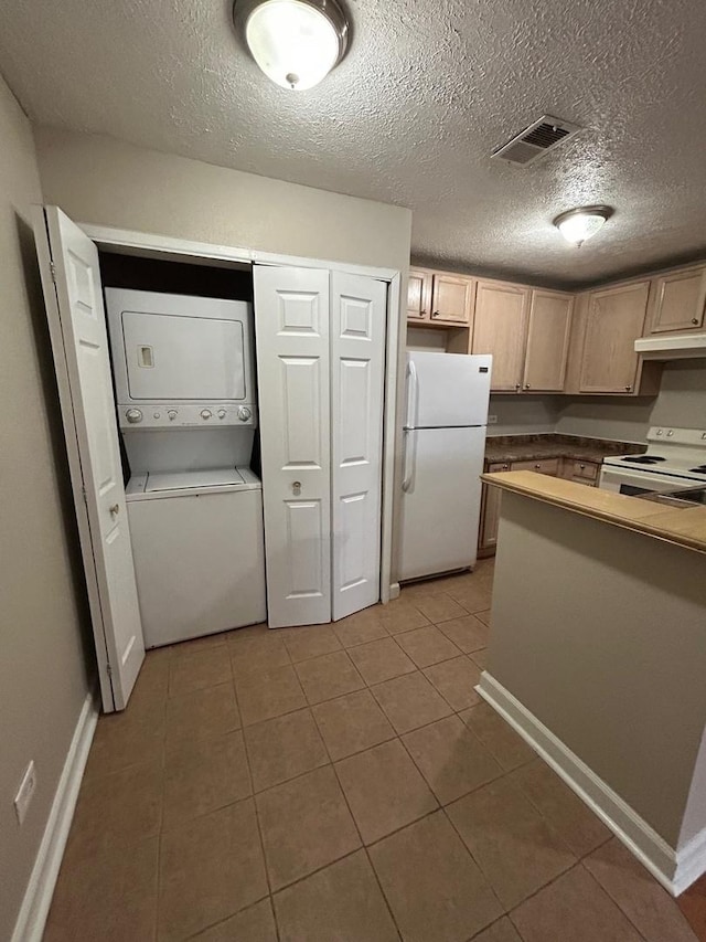2044 N Rand Rd Unit 107, Palatine, IL 60074 - kitchen with white appliances, stacked washing machine and dryer, tile patterned flooring, baseboards, and a textured ceiling