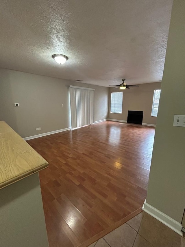 2044 N Rand Rd Unit 107, Palatine, IL 60074 - unfurnished living room with a ceiling fan, wood finished floors, a textured ceiling, and baseboards