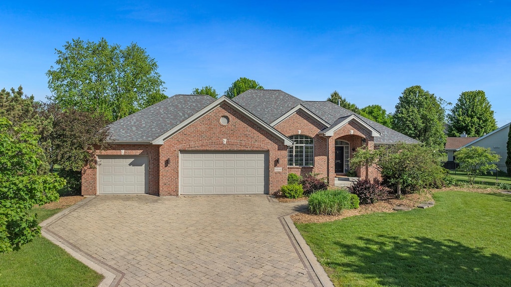 6599 Hartwig Dr, Cherry Valley, IL 61016 - view of front of property with an attached garage, a front yard, brick siding, and driveway