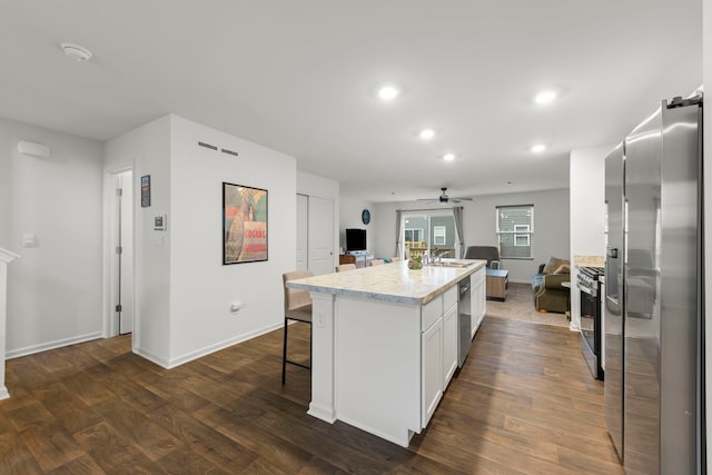 846 Briar Glen Ct, Hampshire, IL 60140 - kitchen featuring appliances with stainless steel finishes, a ceiling fan, dark wood-style floors, white cabinets, and a kitchen island with sink