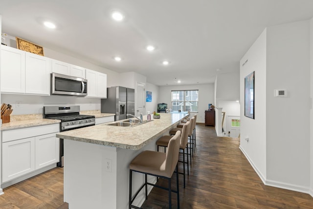 846 Briar Glen Ct, Hampshire, IL 60140 - kitchen with stainless steel appliances, a sink, an island with sink, a kitchen bar, and white cabinetry