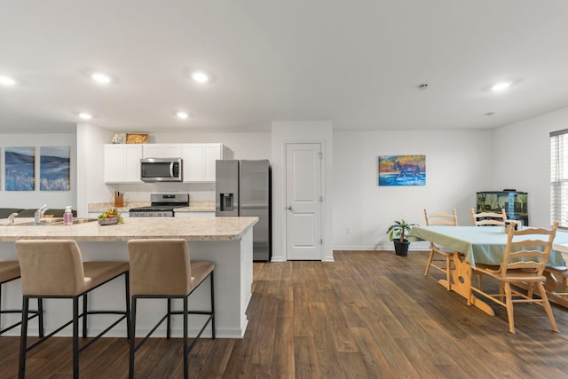846 Briar Glen Ct, Hampshire, IL 60140 - kitchen with appliances with stainless steel finishes, a sink, a kitchen breakfast bar, baseboards, and white cabinets