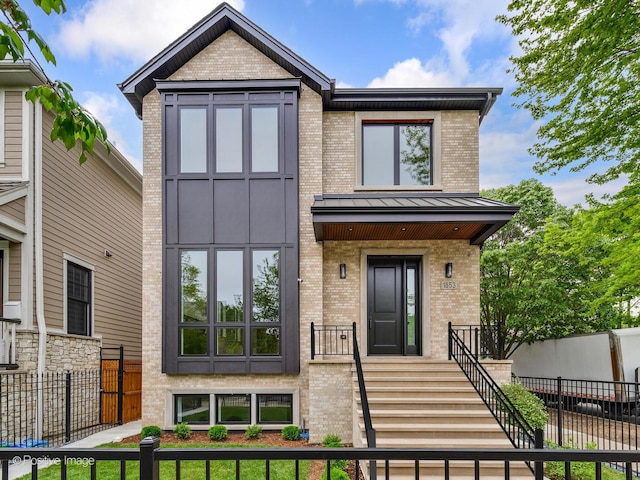 1853 W Barry Ave, Chicago, IL 60657 - view of front of house featuring brick siding, a fenced front yard, and a standing seam roof