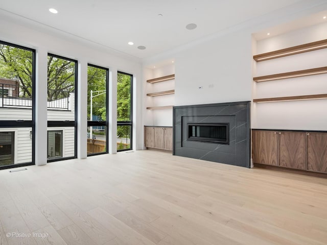 1853 W Barry Ave, Chicago, IL 60657 - unfurnished living room featuring a glass covered fireplace, light wood-style flooring, recessed lighting, and built in shelves