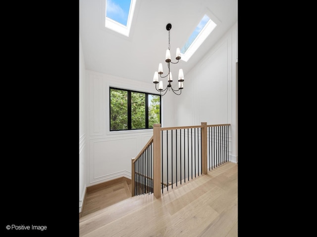 1853 W Barry Ave, Chicago, IL 60657 - stairs with a chandelier, a skylight, vaulted ceiling, and wood finished floors