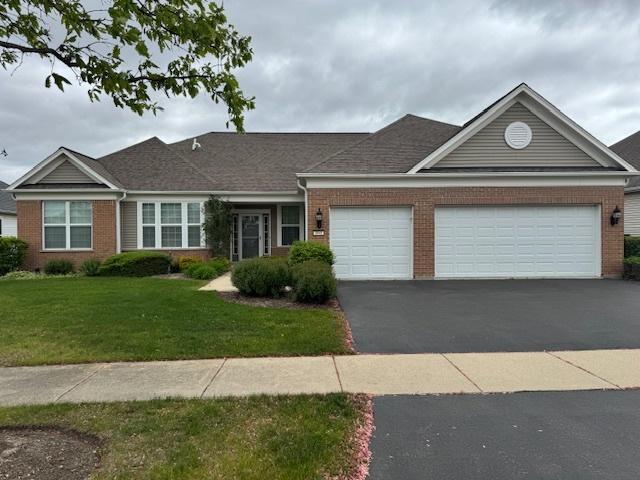 3881 Melody St, Mundelein, IL 60060 - view of front of house featuring brick siding, a garage, and a front lawn