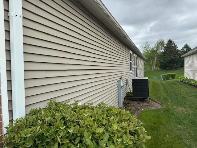 3881 Melody St, Mundelein, IL 60060 - view of property exterior with central AC and a lawn