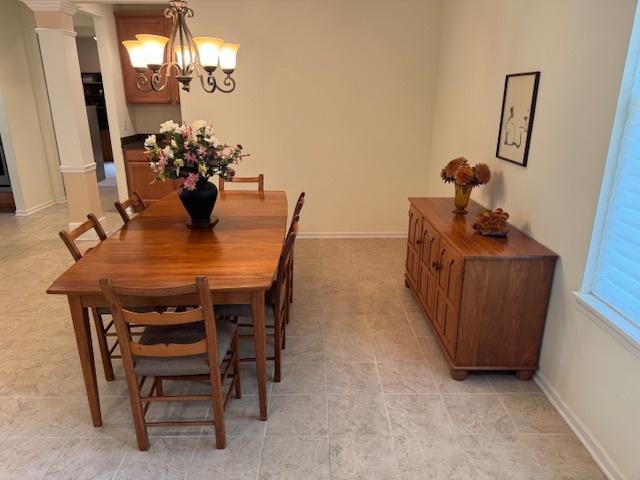3881 Melody St, Mundelein, IL 60060 - dining room featuring decorative columns, a chandelier, and baseboards