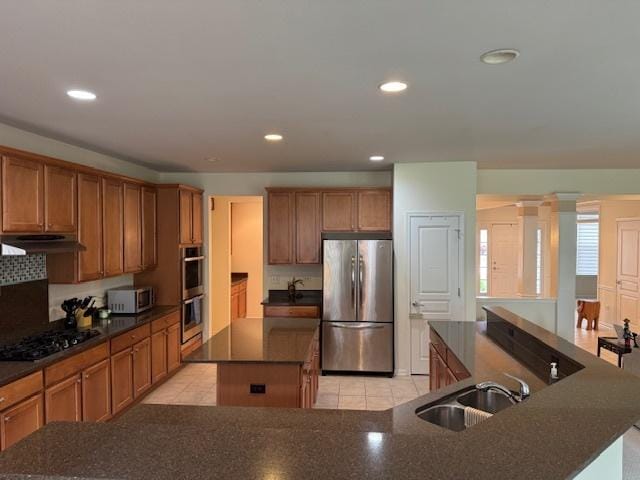 3881 Melody St, Mundelein, IL 60060 - kitchen featuring stainless steel appliances, a kitchen island, a sink, brown cabinetry, and recessed lighting