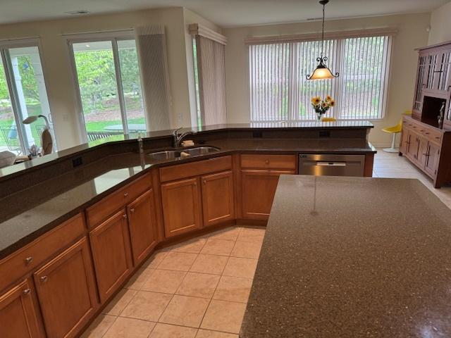 3881 Melody St, Mundelein, IL 60060 - kitchen with brown cabinetry, plenty of natural light, dishwasher, and decorative light fixtures