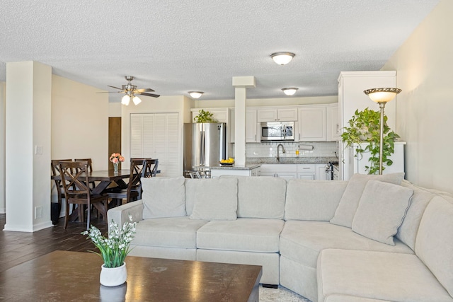 2211 S Highland Ave Unit 1B, Lombard, IL 60148 - living area featuring wood finished floors, ceiling fan, decorative columns, a textured ceiling, and baseboards