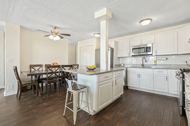 2211 S Highland Ave Unit 1B, Lombard, IL 60148 - kitchen featuring stainless steel appliances, a sink, dark wood finished floors, white cabinetry, and a textured ceiling