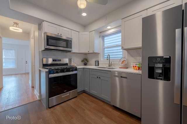 4634 N Hamlin Ave, Chicago, IL 60625 - kitchen with stainless steel appliances, a sink, wood finished floors, light countertops, and plenty of natural light
