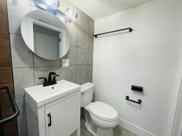 4634 N Hamlin Ave, Chicago, IL 60625 - bathroom with tile walls, vanity, toilet, and tile patterned floors