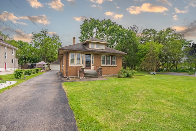 408 Manhattan Rd, Joliet, IL 60433 - bungalow-style home featuring a chimney, a garage, a lawn, brick siding, and an outdoor structure