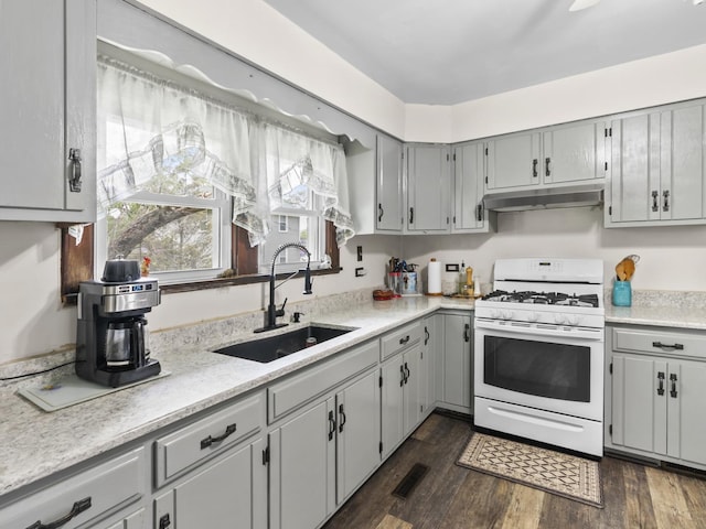 408 Manhattan Rd, Joliet, IL 60433 - kitchen featuring gas range gas stove, a sink, under cabinet range hood, gray cabinetry, and light countertops