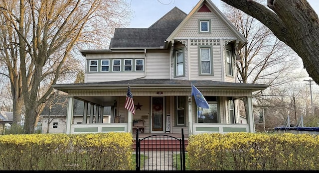 403 E Hickory St, Fairbury, IL 61739 - victorian house featuring covered porch, a fenced front yard, a gate, and a shingled roof