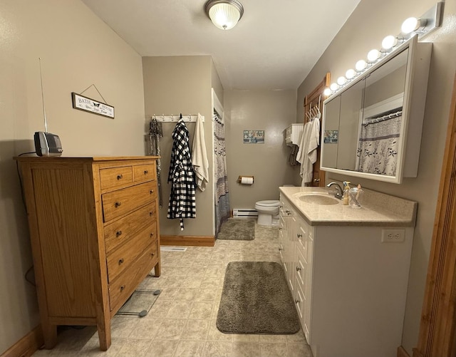 403 E Hickory St, Fairbury, IL 61739 - full bathroom with a baseboard heating unit, vanity, baseboards, and toilet